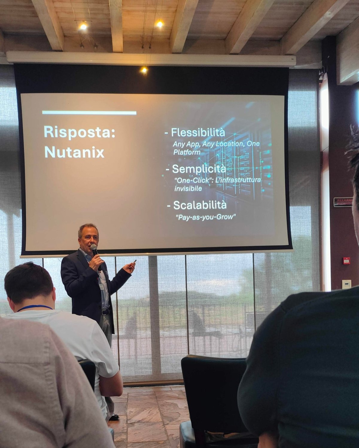 Un tecnico specializzato Nutanix di Baldissar durante il suo intervento a Peschiera del Garda, davanti alla slide sui vantaggi della piattaforma